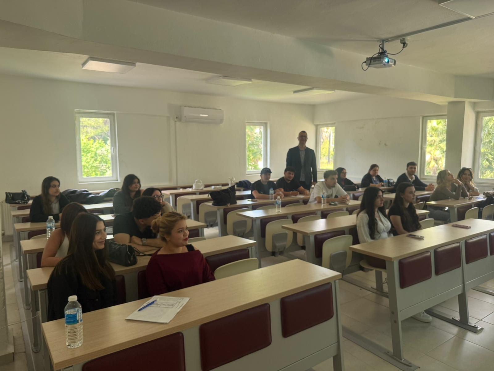  In a classroom, students seated at desks follow the information session held as part of the accreditation meeting.